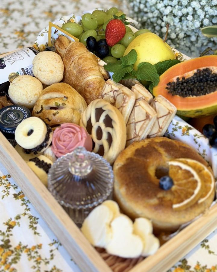 Bandeja de café da manhã da Fiorire com croissants, mamão, uvas, pães e doces